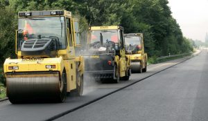 Asphalt rollers drives over new layer of asphalt, with genan rubber powder mixed in.
